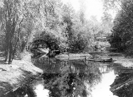 Bridge in wild garden lagoon, c. 1920